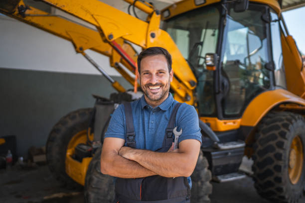 istock Confident car mechanic stand with tool by machinery inside the garage 2174483593