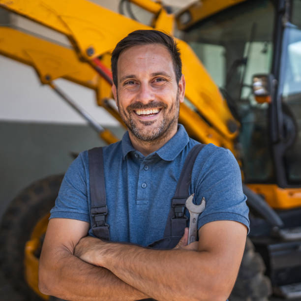 istock Confident car mechanic stand with tool by machinery inside the garage 2174484645