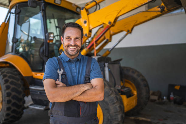 istock Confident car mechanic stand with tool by machinery inside the garage 2174485301
