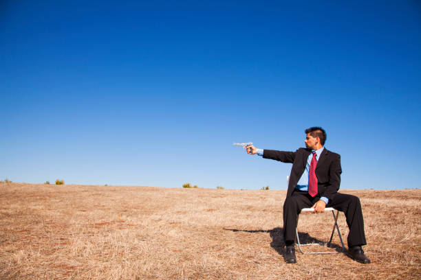 istock Businessman aiming a handgun 2174487492