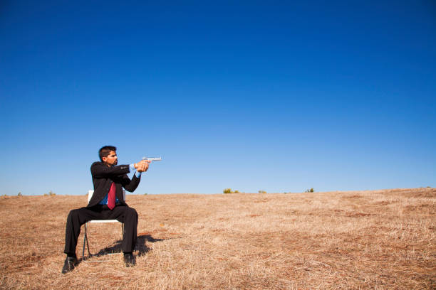 istock Businessman aiming a handgun 2174487518