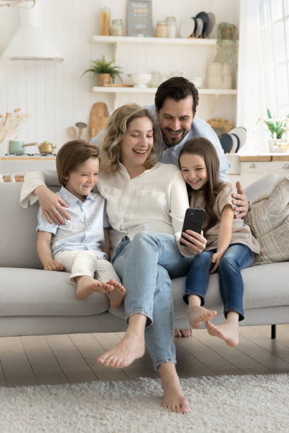 istock Young parents and children using modern smartphone at home 2174488148