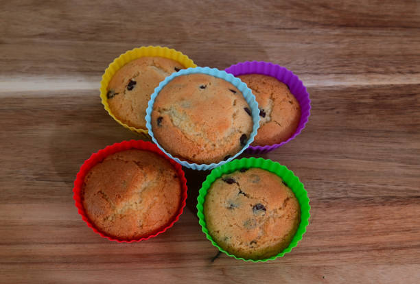 colorful muffins with chocolate drops on the wooden board