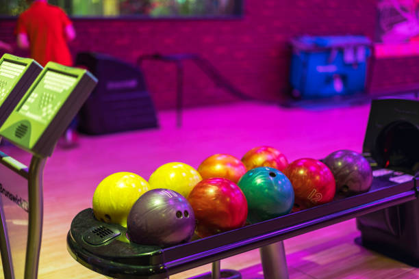 istock Colorful bowling balls on rack at ball return system in bowling alley with electronic scoreboards. 2174494503