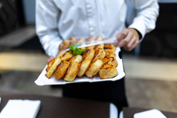 istock A waiter serving freshly baked pastries at a catering event in a modern dining setting during the afternoon 2174502246