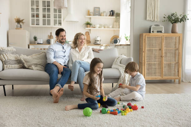 istock Children play at home while parents relaxing on sofa 2174503520