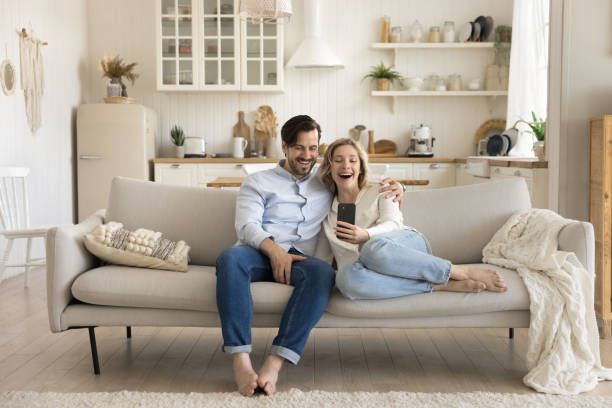 istock Smiling family rest on sofa use cellphone 2174503618