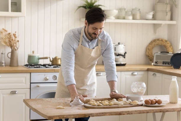 istock Positive young man flattening dough with rolling pin 2174505437
