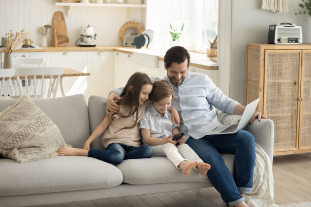 istock Happy family use electronic devices at home 2174505617