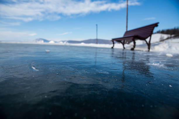 A picturesque scene featuring a frozen lake, complete with a bench situated in the background, providing a serene vantage point