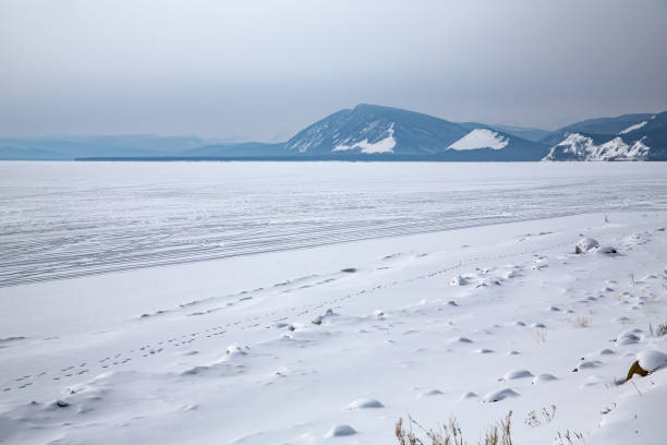 frozen lake and a person stand in the end of the horizon