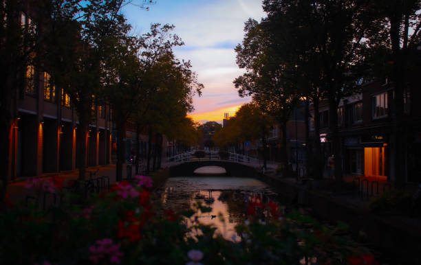 Sunset over the canal, and a quiet street in downtown Delft. Delft is known for its porcelain and university engineering program (taught at the Delft University of Technology - TU Delft). Delft is located between Rotterdam and The Hague. This shot was taken during autumn.
