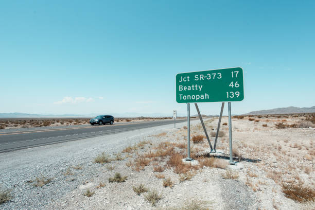 istock Highway in desert with sign standing next to it 2174514206