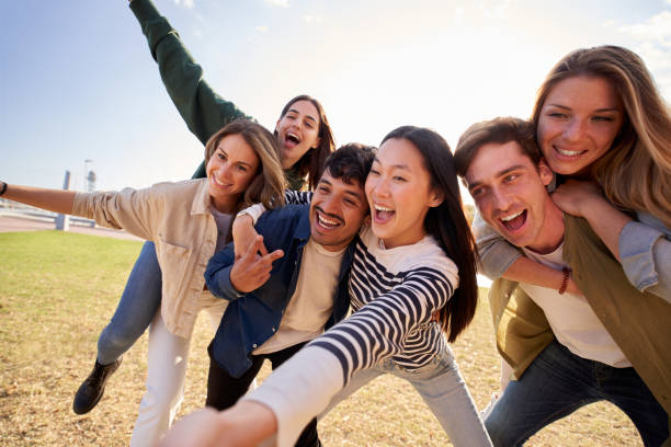 istock Young people smiling and posing in a field under a cloudy sky 2174514208