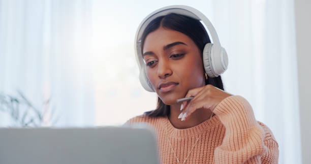 istock Laptop, learning and music with Indian woman in home office for online study or remote work. Computer, listening and reading with freelancer in apartment for future planning or problem solving 2174524606