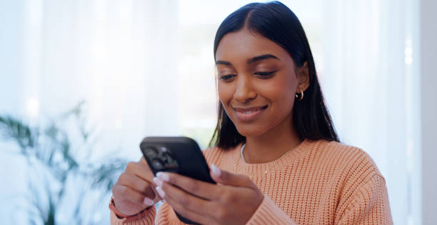istock Home, Indian woman and connection with smartphone for chat, message and communication with contact. House, female person or phone with mobile app for scroll, share reel and online dating with smile 2174524656