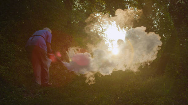 LENS FLARE: Person preparing a dramatic misty film set using a fog machine