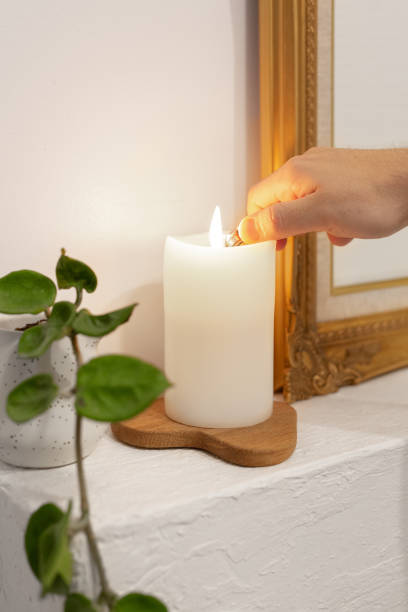 istock Hand Lighting White Candle On Wooden Holder Near Frame 2174531018