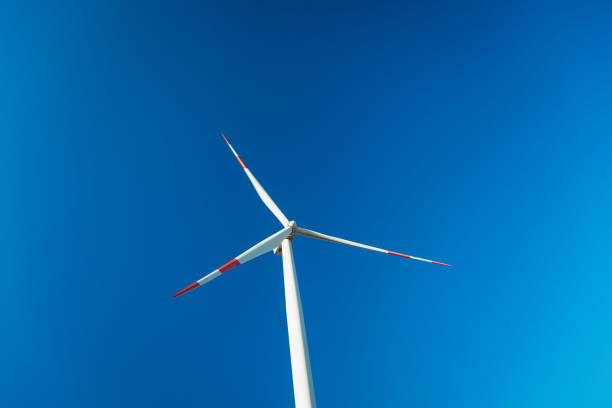 Wind turbines on a renewable energy farm in a rural Serbian landscape, operating under bright sunny skies, highlighting sustainable green energy sources.
