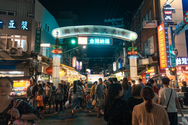 Vibrant night market in Taipei, Taiwan bustling with people enjoying local delights and culture Under the glowing lights of Taipei's night market, crowds fill the streets, savoring delicious food and vibrant local culture taiwan people stock pictures, royalty-free photos & images