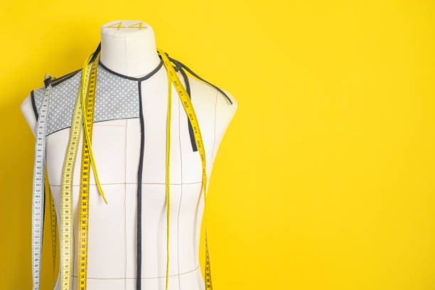 istock White mannequin with main marks on a yellow wall background. Centimeter measuring tapes. 2174539748