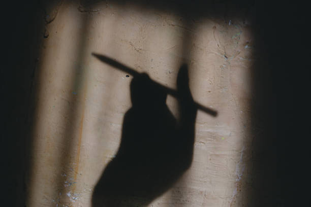 istock Shadow of a person's hand holding a pencil on the wall 2174548686