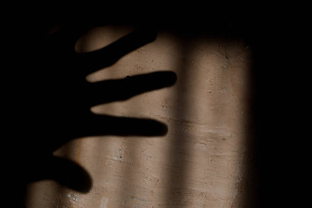Shadow on the wall from the palm of a person's hand