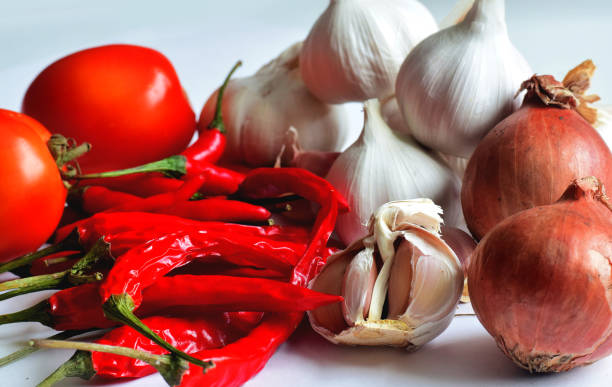 Chili, garlic, dried shallots, tomatoes on white background