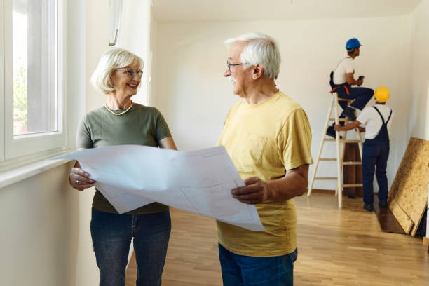 istock Happy mature couple talking about blueprints during home renovation process. 2174570547
