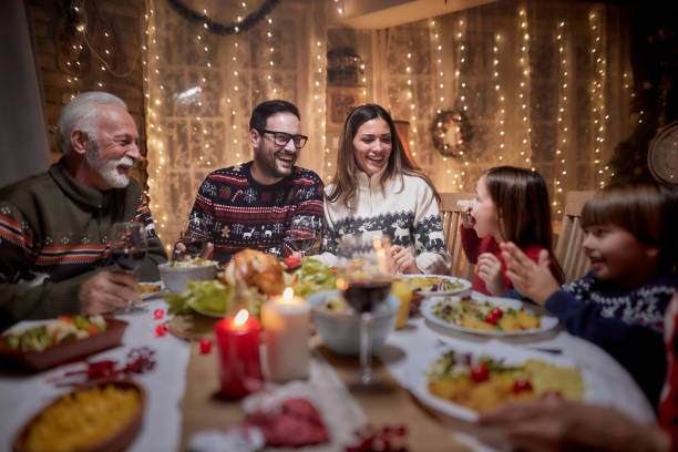 Cheerful extended family talking during Christmas dinner at home.