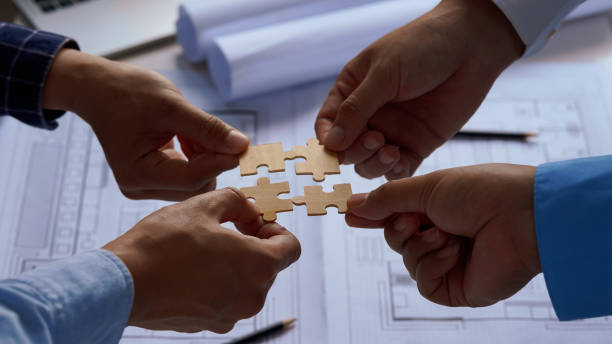 istock Teamwork and partnership concept. Business solutions, success and strategy concept. Hands connecting puzzle. Hand of the team fold puzzle, closeup. 2174576919