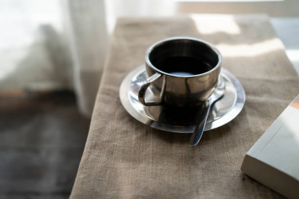 stainless steel coffee cup on table in sunlight