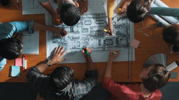 istock Top down view of engineer team writing at blueprint at meeting table. Symposium. 2174579915