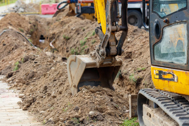 istock A yellow and black construction vehicle is digging a trench 2174580462