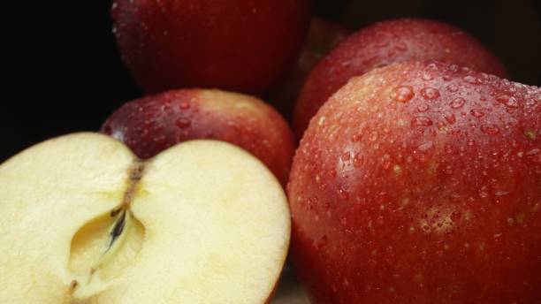 istock Macrography, slices of apple placed on board with black background. Comestible. 2174581432