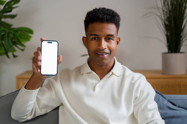 istock Young man smiling showing smartphone with tracking markers on sofa at home 2174581740