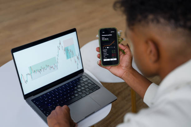 istock Trader analyzing stock market data on laptop and smartphone 2174581899