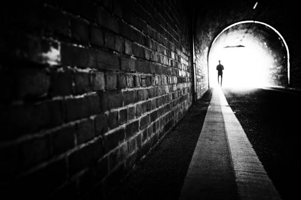 istock Tunnel, person, silhouette, bricks, light, monochrome 2174583059