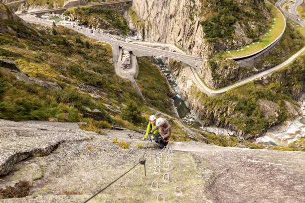 istock Climbers Scaling a Steep Rock Face Overlooking a Scenic Valley 2174584695