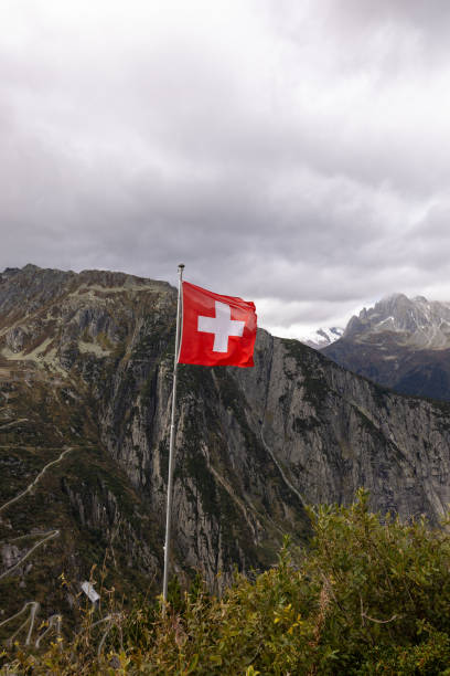 istock Swiss Flag Flying Over Majestic Mountain Landscape 2174585017