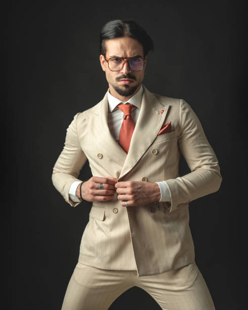 istock confident businessman buttoning his beige suit 2174588587