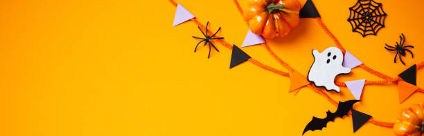 istock Halloween banner design with bunting, spiders, ghosts, bats, pumpkins on orange background. 2174588772