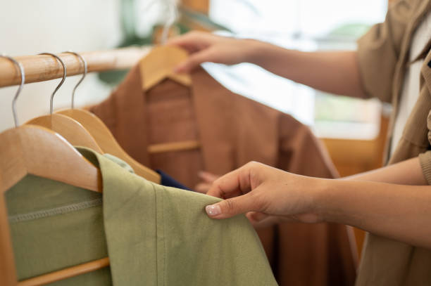 istock Females selecting clothes from a rack, enjoying their shopping experience together. 2174590049