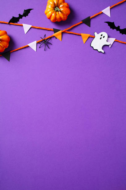 istock Halloween vertical banner with bunting, ghosts, pumpkins, bats, spiders on purple background. Flat lay, top view,, copy space. 2174590344