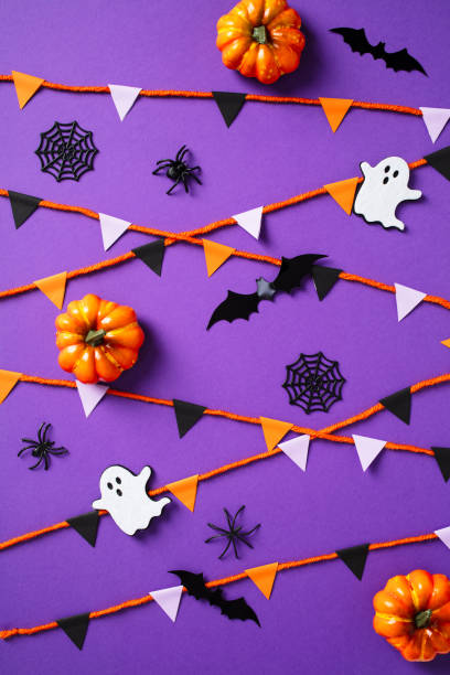 istock Happy Halloween concept with bunting, ghosts, pumpkins, web, bats, spiders on purple background. 2174590418