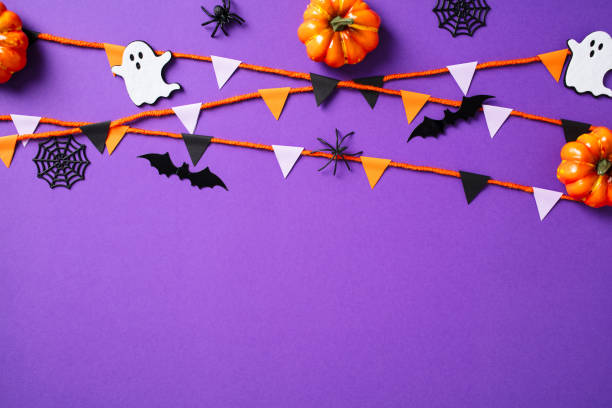 istock Happy Halloween concept. Flat lay composition with pumpkins, spiders, ghosts, webs, bunting garland on purple background. 2174590547