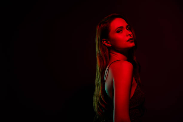 istock Stunning charming fashion model posing empty space isolated on dark red neon color background 2174592348