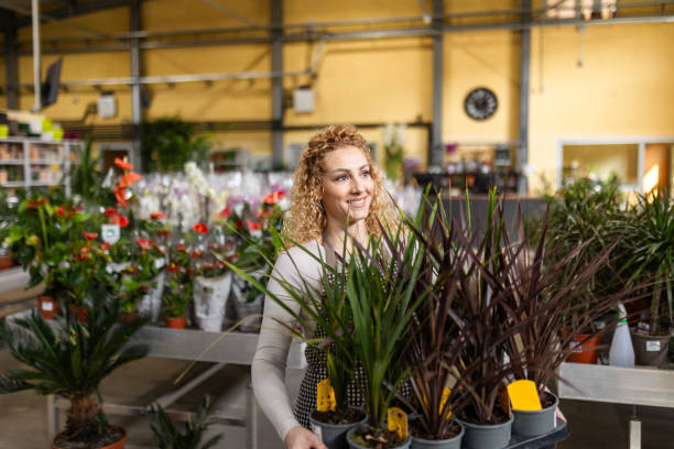 istock Young Woman Caring for Plants in Garden Centre 2174600370