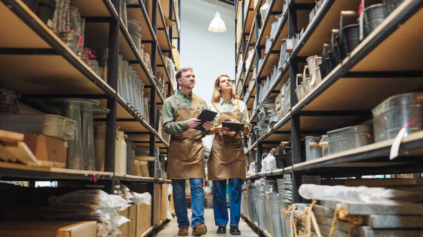 istock A small business warehouse  worker owner wearing aprons counting  checking stock  management on shelves discussing inventory in a well-organized storage compartment checklist 2174600805