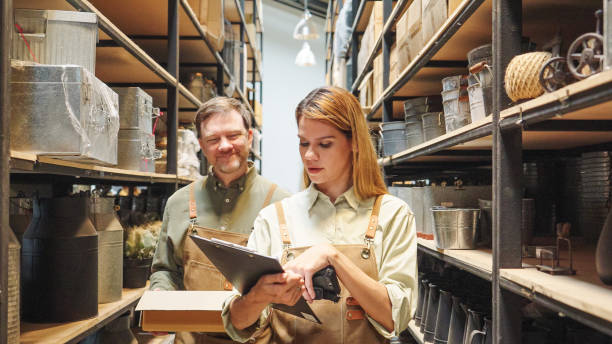 istock A small business warehouse  worker owner wearing aprons counting  checking stock  management on shelves discussing inventory in a well-organized storage compartment checklist 2174600828